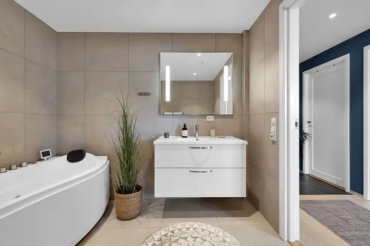 Badet er pent og praktisk med både badekar og dusj
